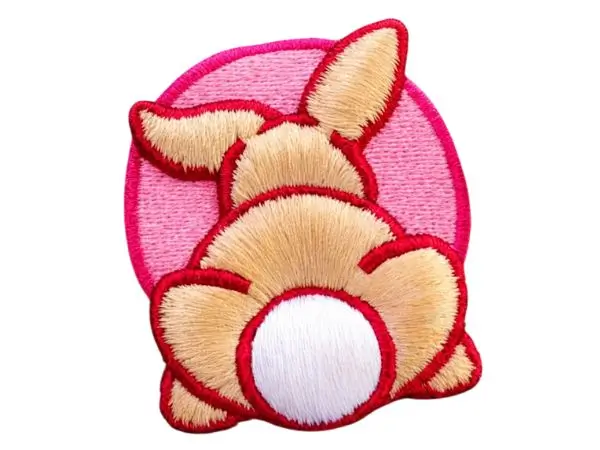3d puff embroidered patch showing cartoon bunny from back with beige body, white tail, red-outlined ears on pink circular background