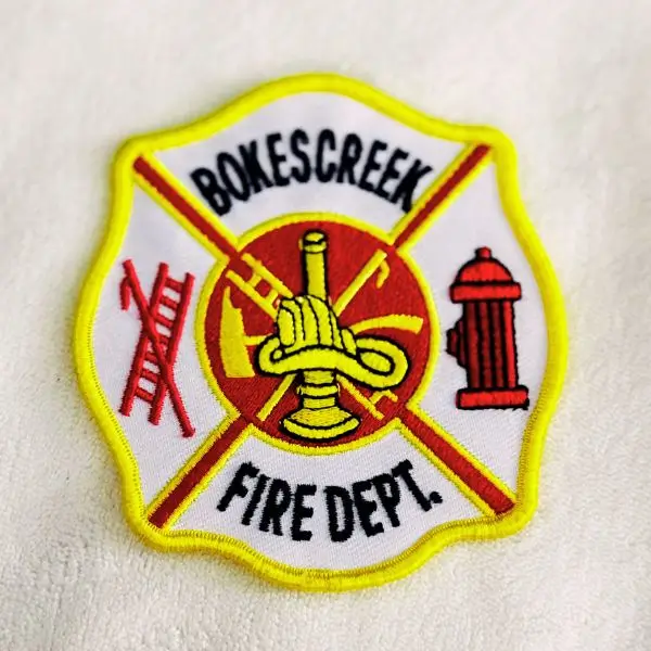 Maltese-cross shaped fire department patch reading 
